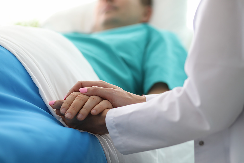 Female doctor hands hold male patients hand in hospital